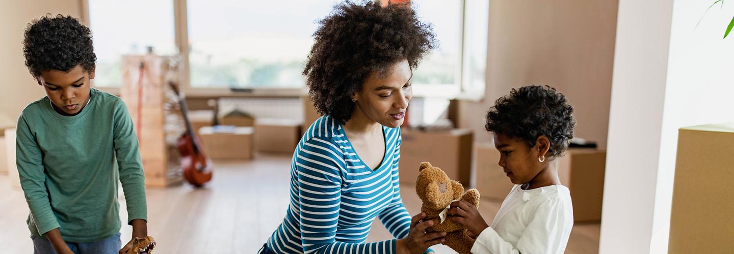 a mother and her children unpack moving boxes