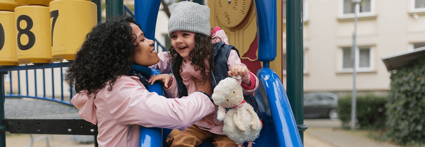 mother and daughter on slide at playground