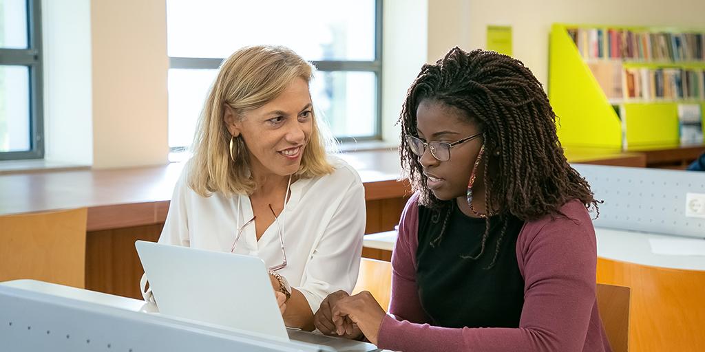 two women work together