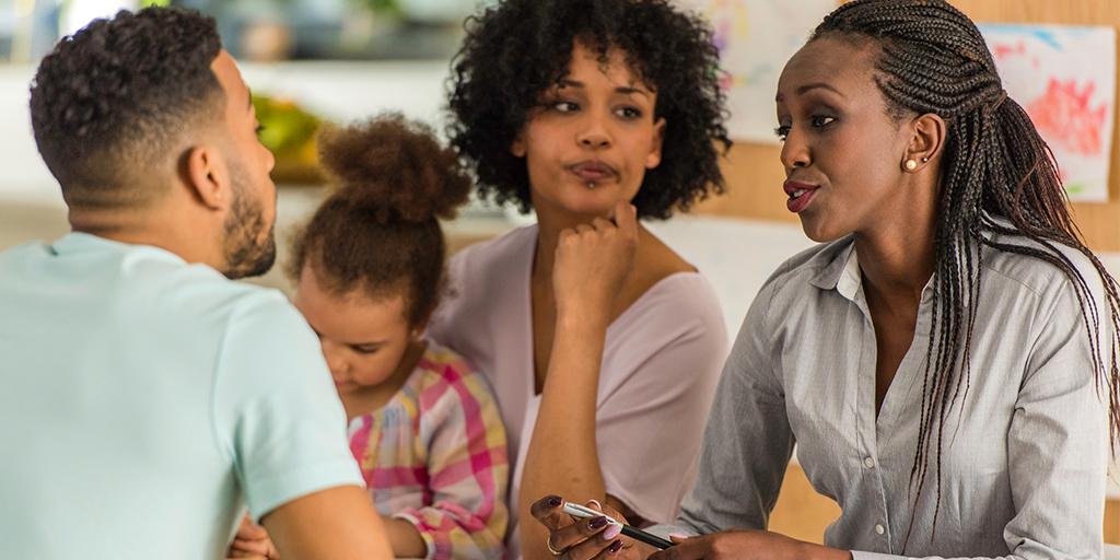 parents with their child listening to an adult