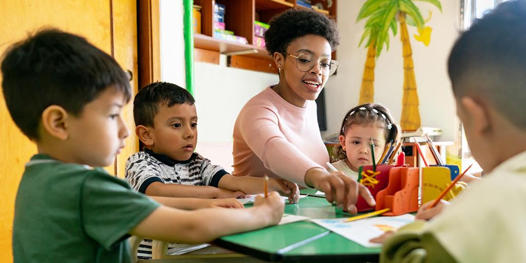 a teacher works with a group of young students